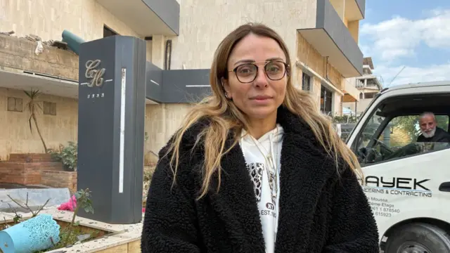Woman stands outside Comfort Hotel, which was struck in an Israeli strike