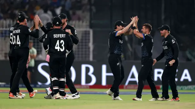 Cole McConchie of New Zealand celebrates with teammates after taking the wicket of Ryan Rickelton of South Africa