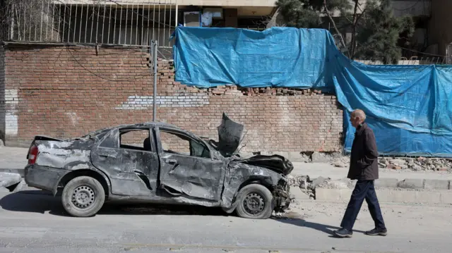 An Iranian man walks next to a damaged building in central Tehran, Iran, 04 March 2026