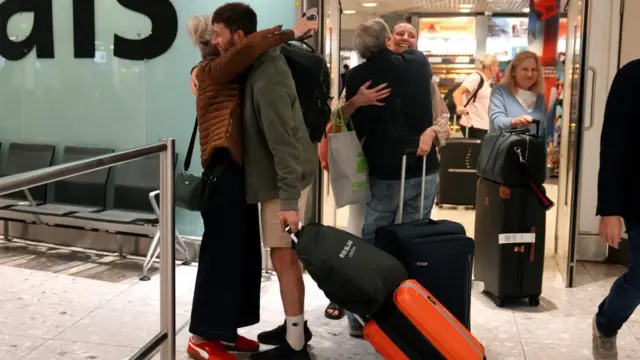 Loved ones hug each other at Heathrows arrivals