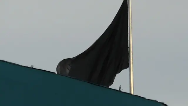 A black flag shown flying in the sky
