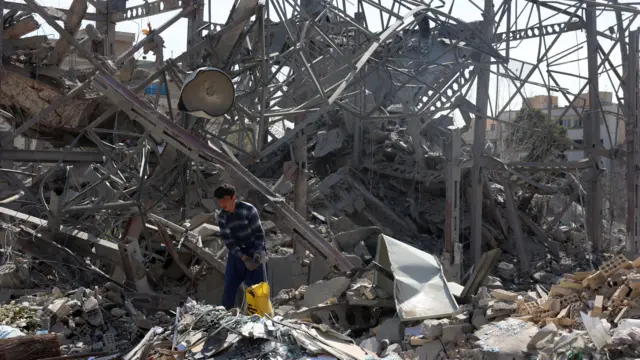 An Iranian worker cleans the damage to a building in central Tehran, Iran, 04 March 2026