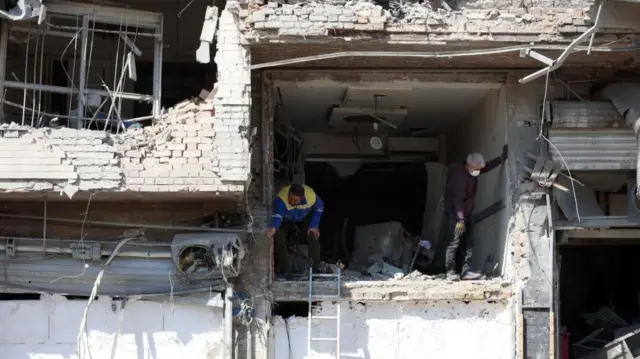 A blown out building with two men standing inside