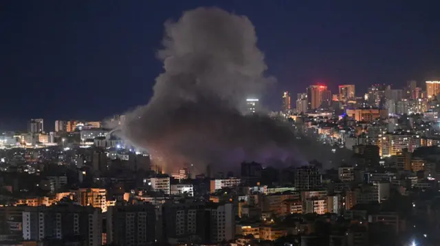 smoke rising from an area of buildings in a city