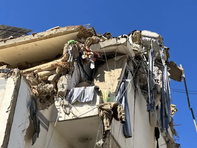 Close up of damage to a residential building on the outskirts of Beirut. Clothes and linens are tangled in debris and cables