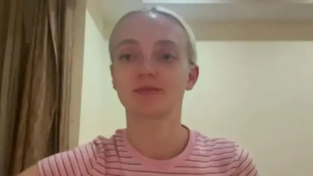 Woman in striped t shirt sitting in a hotel room
