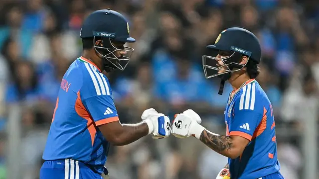 India's Sanju Samson (L) and Ishan Kishan bump their fists during the 2026 ICC Men's T20 Cricket World Cup semi-final match between India and England at the Wankhede Stadium in Mumbai