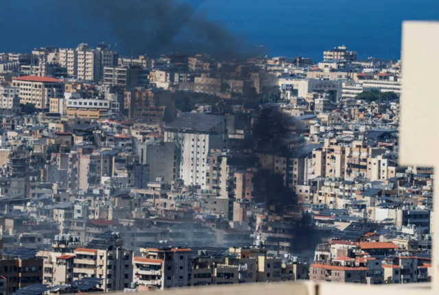 Black smoke rises from among residential buildings in Beirut