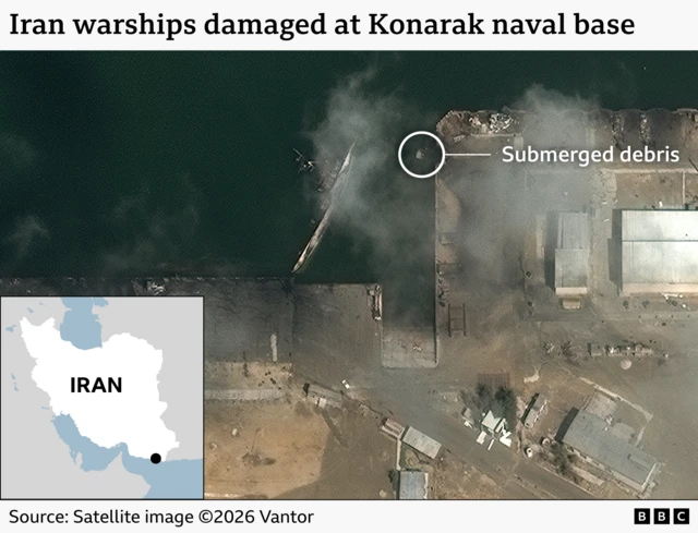 A satellite image showing a pariially submerged warship and a small amount of submerged debris