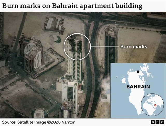 A satellite image of a large multi-storey building from the side, you can see burn marks covering two sides of it over around 10 floors