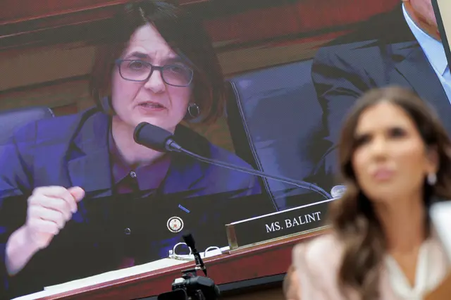 Rep Becca Balint on a video screen behind Kristi Noem