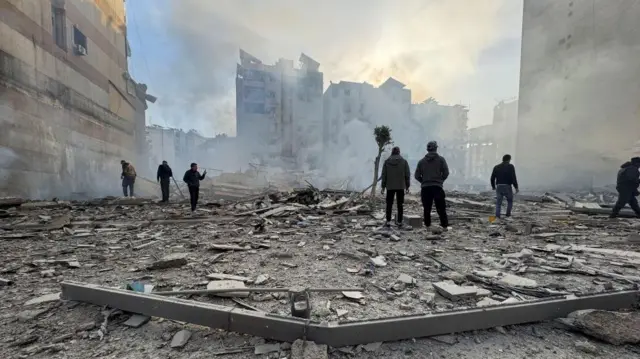 People inspect rubble on the ground in Beirut
