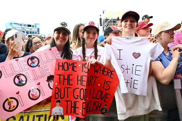 Fans hold up signs in the Melbourne fan zone