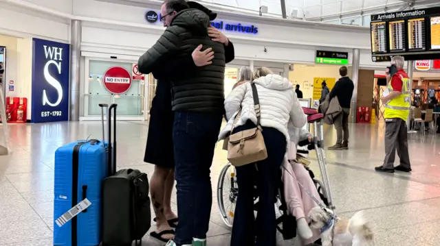 People hug on the arrivals of Stansted Airport following return to the UK on the Government’s first charter flight to evacuate British nationals from the Middle East
