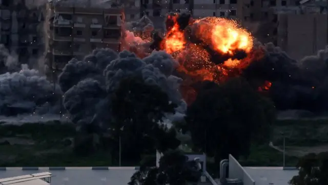 A fireball is pictured amid buildings, with smoke billowing from the site