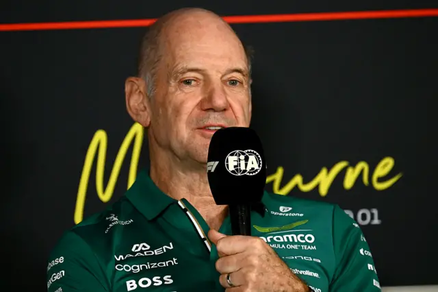Adrian Newey holds a microphone in the press conference