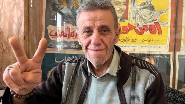 Mohamed Baydoun throwing up a peace sign at the camera