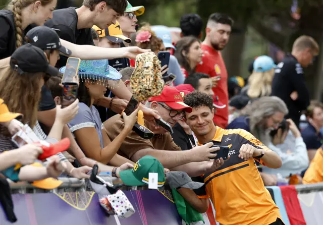 Lando Norris takes pictures with fans in Melbourne before practice