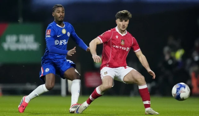 Chelsea's Jorrel Hato (left) and Wrexham's Ryan Longman battle for the ball
