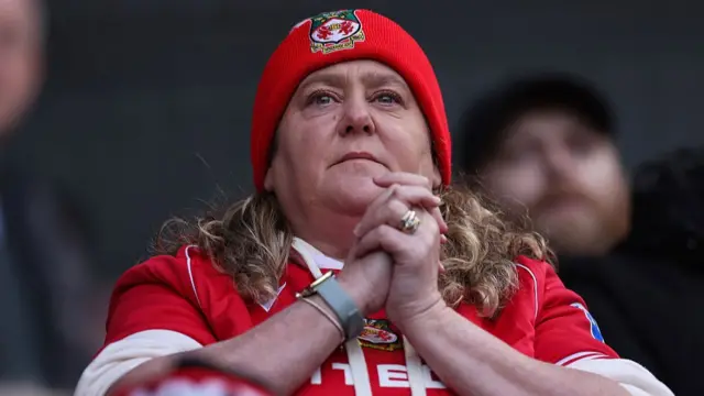 A Wrexham fan watches their team in a Championship match