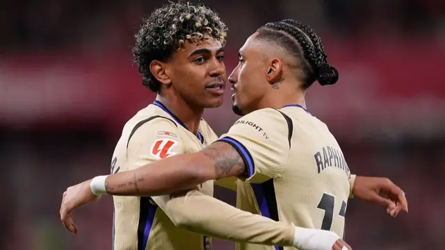 Lamine Yamal of FC Barcelona celebrates scoring his team's first goal with teammate Raphinha