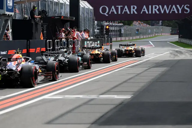 Cars line up at the end of the pit lane