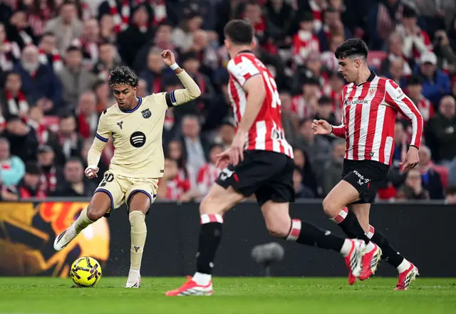Lamine Yamal of FC Barcelona controls the ball whilst under pressure from Alejandro Rego of Athletic Club