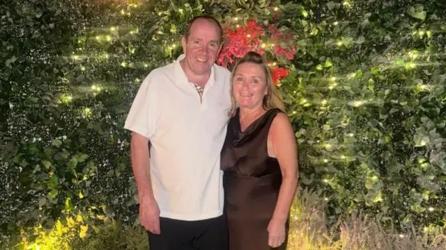 A couple stand in a garden