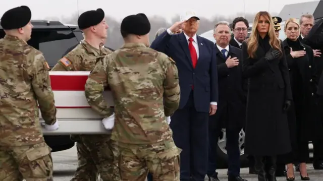 Trump and th efirst lady are seen saluting a casket as soldiers carry it on front of them