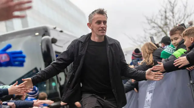 Ipswich Town head coach Kieran McKenna, dressed all in black, is greeted by fans as he arrives at Portman Road