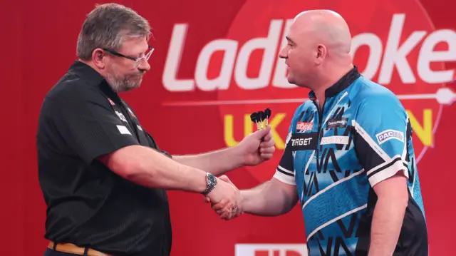 James Wade shakes hands with Rob Cross