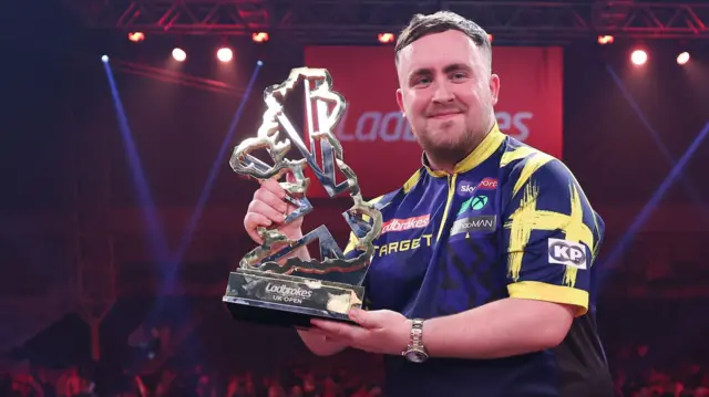 Luke Littler holds the UK Open trophy