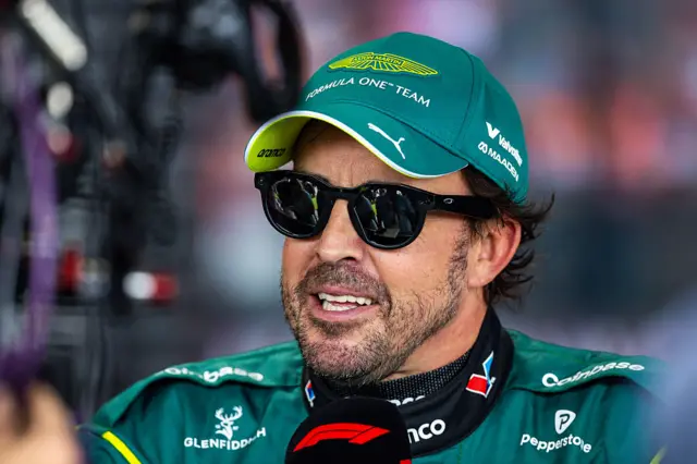 Fernando Alonso wearing sunglasses in front of the microphone in the Melbourne media pen