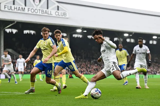 Oscar Bobb crosses the ball whilst under pressure from James Bree