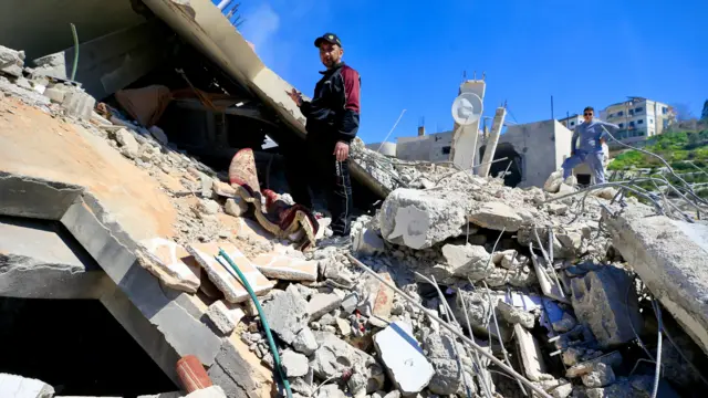 A man walks amongst the rubble of a building targeted in an Israeli airstrike in Sir el-Gharbiyeh, southern Lebanon