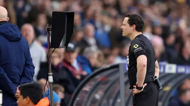 Darren England looking at VAR screen