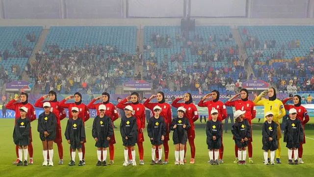 Iran's women's national football team salutes ahead of a match against the Philippines at the Women's Asian Cup