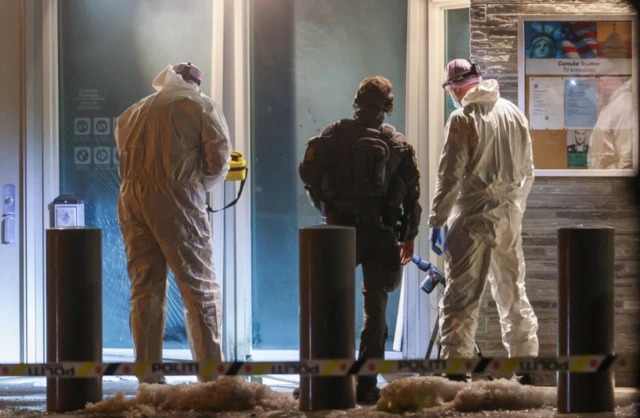 Police officers and technicians inspect the American embassy after a loud bang was reported at the site, in Oslo
