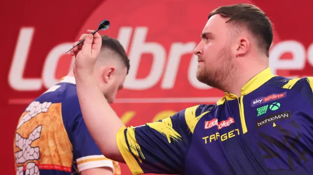 Luke Littler throws a dart