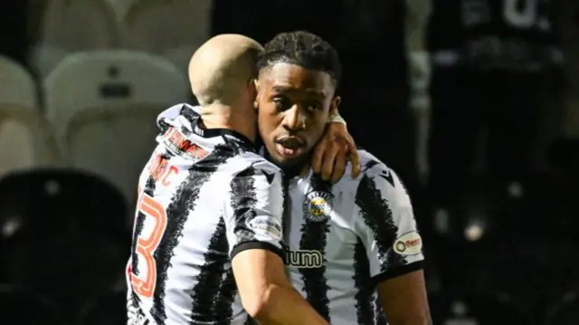 Dan Nlundulu gets a cuddle from Alex Gogic