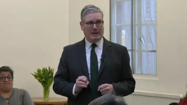 Starmer speaks to a group of people in a community centre