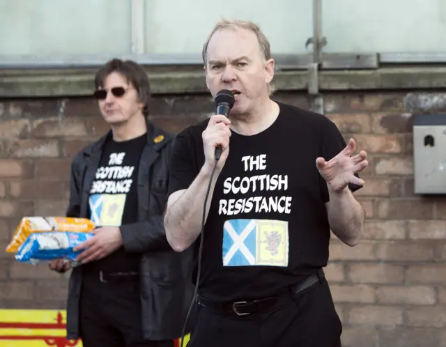 Activists Sean Clerkin (right) and James Scott from the Scottish Resistance group take part in a protest outside Tunnock's factory in Uddingston, Lanarkshire,