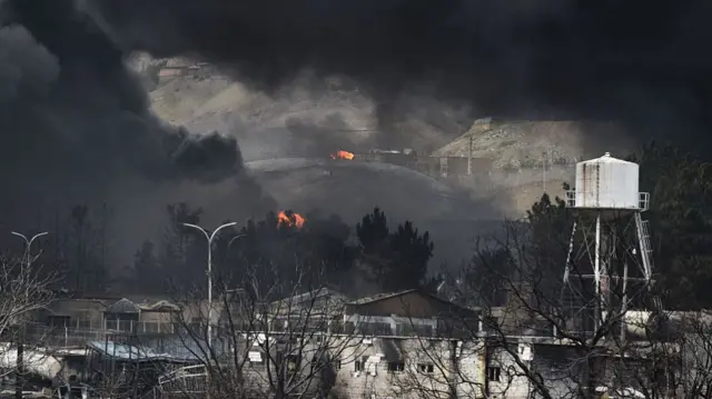 Plumes of smoke rise over the oil depot tanks hit by joint Israel-U.S. over night in a station north west of the capital on March 8, 2026