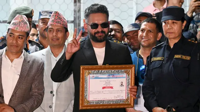Balendrah Shah gestures with a V sign using his right hand after winning the Japha 5 constituency in the Nepal 2026 election