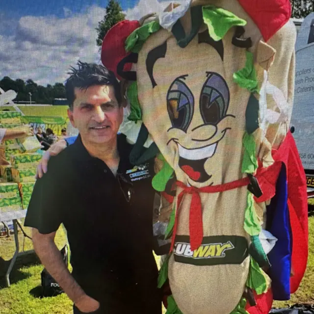 Wahid Sadiq standing next to a Subway mascot