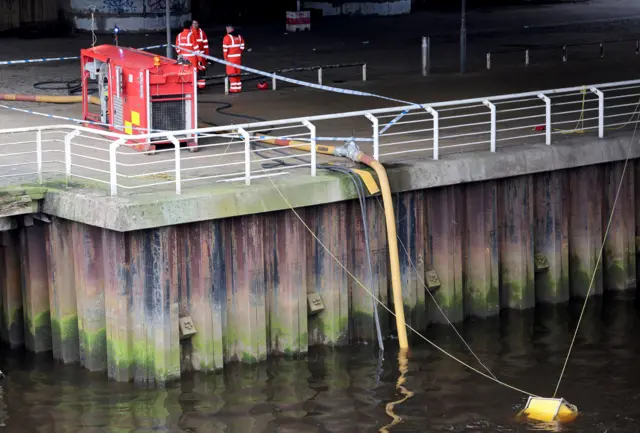 Fire crews pump water from the River Clyde to use as they damp down the remains of a fire which broke out in a building adjacent to Glasgow Central railway station on Sunda