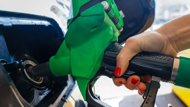 A file photo of a person putting petrol in their car