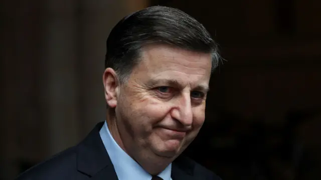 Secretary of State for Scotland Douglas Alexander walks at Downing Street. He wears a suit and has short dark grey hair