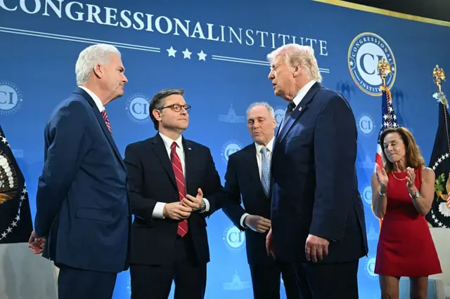 President Donald Trump talks to Republican congressional leadership against a blue backdrop