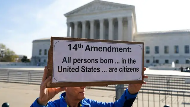 A man holds a sign outside of the US Supreme Court.